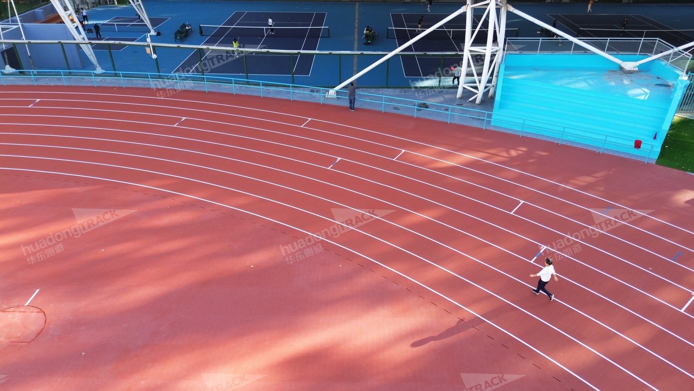 Runner using the curved red track at Xian University of Architecture and Technology